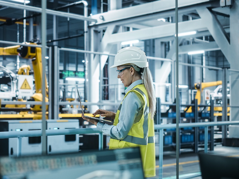 Employee with notebook in a production hall
