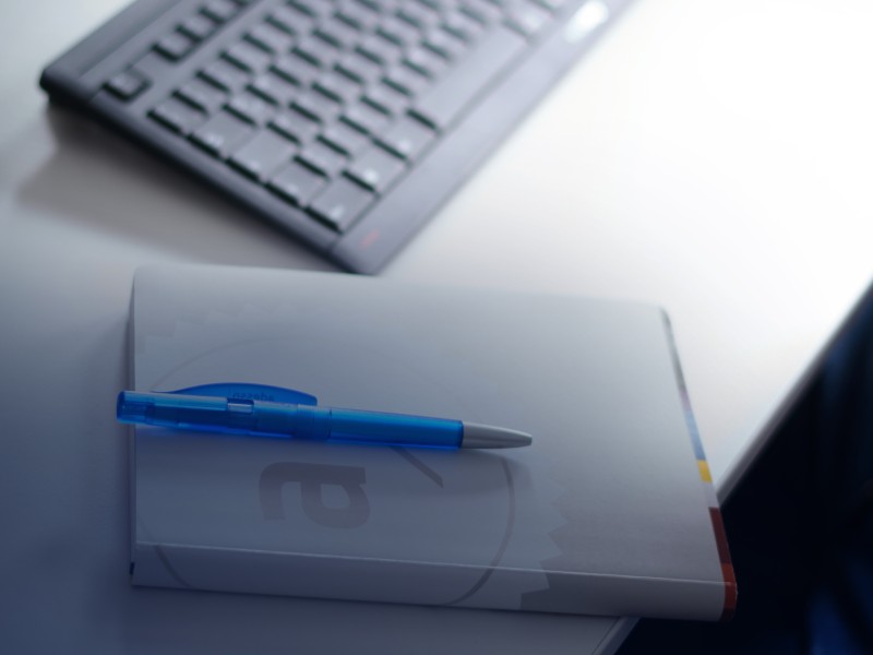 Keyboard, pen and pad on a desk